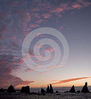 Silhouette of Hashigui-iwa Rocks and purple clouds at dawn photo