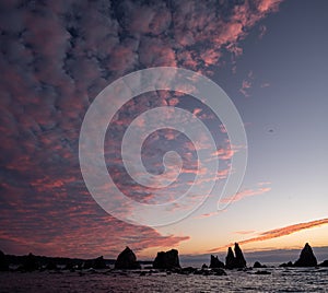 Silhouette of Hashigui-iwa Rocks and purple clouds at dawn photo