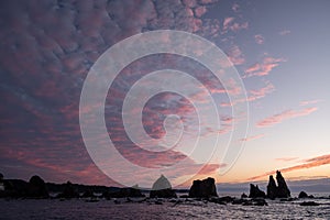 Silhouette of Hashigui-iwa Rocks and purple clouds at dawn photo