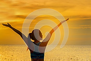 Silhouette healthy woman lifestyle relaxing and exercising vital meditate and practicing yoga on the beach at sunset