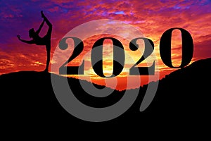 Silhouette of healthy woman practicing yoga on the hill and 2020 years with sky twilight. concept celebrating new year