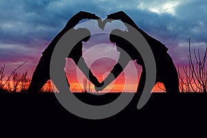 A silhouette heart opposite the sunset view