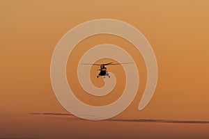 Silhouette of helicopter with sunset sky