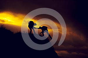 Silhouette of helping hand between two climber