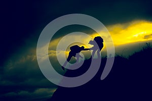 Silhouette of helping hand between two climber
