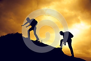 Silhouette of helping hand between two climber