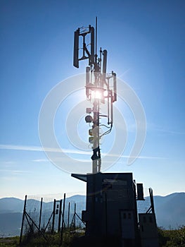 Silhouette of a high cellular telecommunication base station antennas on a sunny day