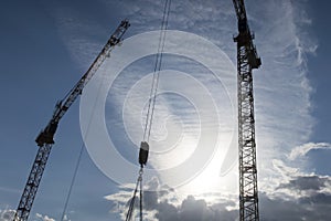 Silhouette of high construction cranes