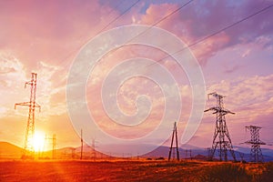 Silhouette high voltage electric pylon and electrical wire with an orange sky. Electricity poles at sunset. Power and energy