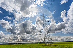 Silhouette of the high voltage electric pylon towers on the background of beautiful clouds