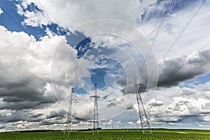 Silhouette of the high voltage electric pylon towers on the background of beautiful clouds