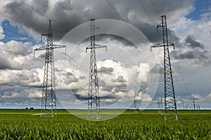 Silhouette of the high voltage electric pylon towers on the background of beautiful clouds