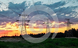 Silhouette High voltage electric towers at sunset time. High-voltage power lines.