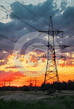 Silhouette High voltage electric towers at sunset time. High-voltage power lines.