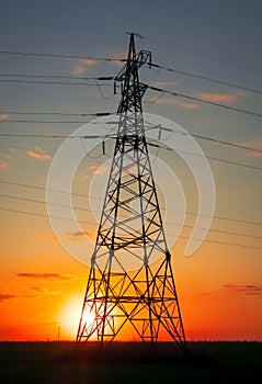 Silhouette High voltage electric towers at sunset time. High-voltage power lines. Electricity distribution station