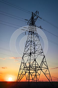 Silhouette High voltage electric towers at sunset time. High-voltage power lines. Electricity distribution station