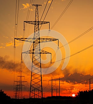 Silhouette High voltage electric towers at sunset time. High-voltage power lines. Electricity distribution station