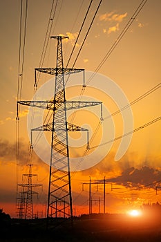 Silhouette High voltage electric towers at sunset time. High-voltage power lines. Electricity distribution station