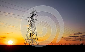 Silhouette High voltage electric towers at sunset time. High-voltage power lines. Electricity distribution station