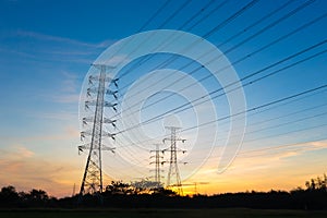 Silhouette high voltage electricity pylon on sunrise background