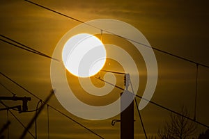 A silhouette of high voltage power lines against a dramatic and