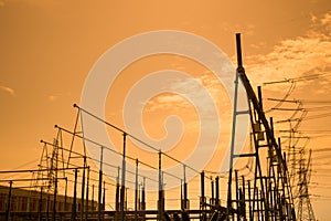 Silhouette of high voltage power plant and transformation station at sunset photo