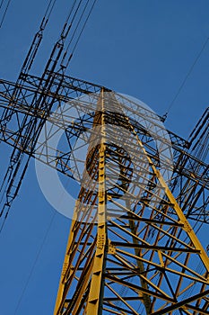 Silhouette of a high-voltage pylon in the blue evening sky.