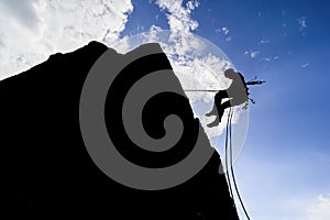 Silhouette of a hiker in an extremely dangerous pose trying to find new adventures photo