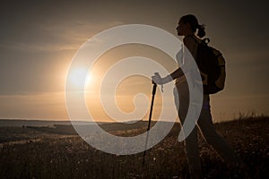 Silhouette hiker woman tracking with backpack