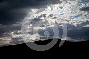 Silhouette of hikers on top of a hill during sunset