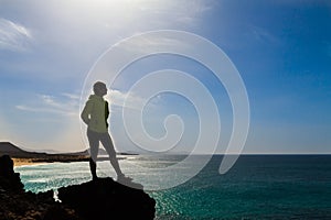 Silhouette of hiking woman near sea