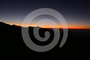 Silhouette of Himalayan mountain ranges and hills as the sun rises, viewed from the summit of Poon Hill, Nepal