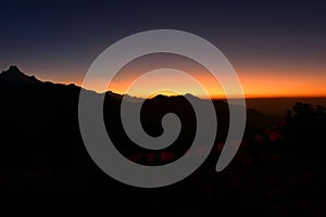 Silhouette of Himalayan mountain ranges and hills as the sun rises, viewed from the summit of Poon Hill, Nepal