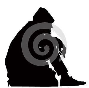 Silhouette of Homeless Hobo Sitting with His Possessions photo