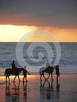 Silhouette of horsemen at sunset. photo