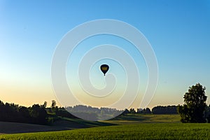 Silhouette hot air balloon in blue sky landscape background.Hot air balloon over the green field