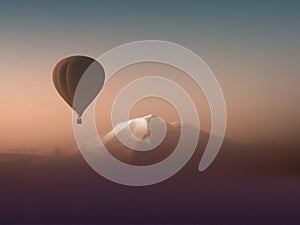 Silhouette hot air balloon flying over the mountains