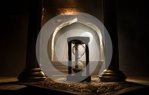 Silhouette of hourglass inside room. Abstract surreal idea with empty space. Selective focus