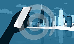 The silhouette of a human hand using a mobile phone against the backdrop of a modern western winter cityscape. Vector