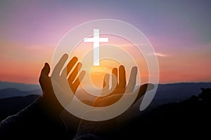 Silhouette of human hands palm up praying and worship of cross, eucharist therapy bless god helping, belief, forgiveness, freedom