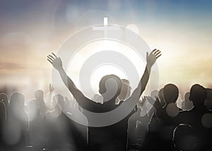 Silhouette human raising hands to praying God on blurred cross background