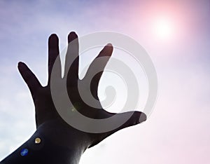 The silhouette humand hand reaching to the sky,Lens flare effect