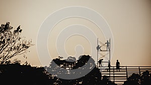 Silhouette image of a group of workers working on scaffolding for construction