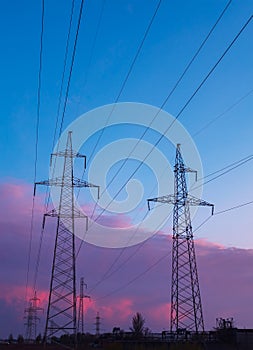 Silhouette image of the high voltage electricity pole with sky on sunset time.