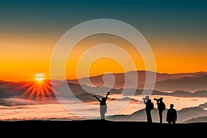 Silhouette image of traveler men and women taking photos with sunrise in the morning on mountains natural background
