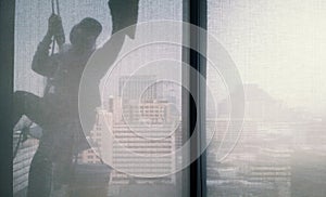 Silhouette images of man cleaning the window office building