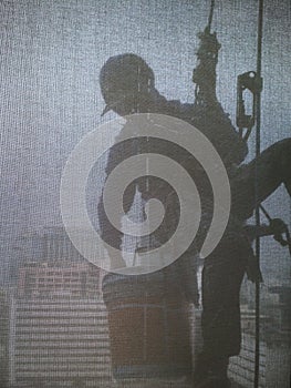 Silhouette images of man cleaning the window office building