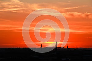 Silhouette of industrial city at sunset.