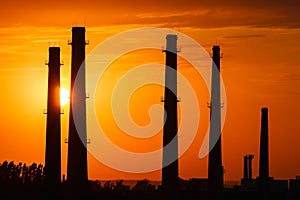 Silhouette of industrial factory at golden sunset