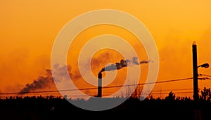 Silhouette of an industrial factory on a sunset background